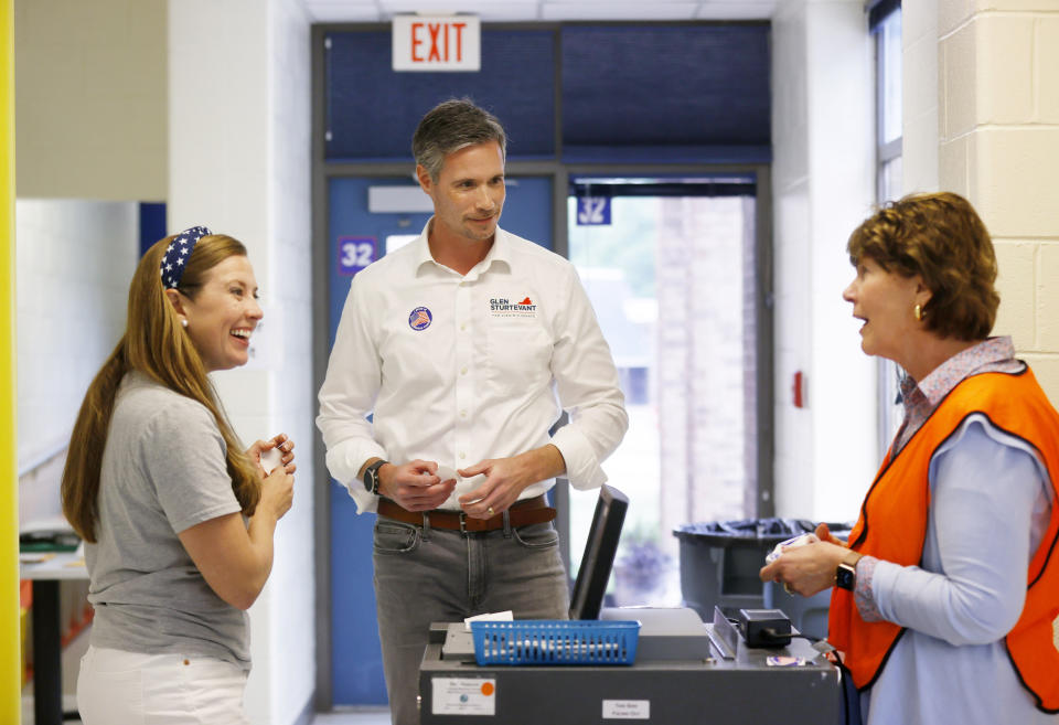 Lori Cochrane Sturtevant, from left, and Glen Sturtevant talk to poll worker Pam Maxey after casting their ballots on Tuesday, June 20, 2023, at Robious Elementary School in Midlothian, Va. (Margo Wagner/Richmond Times-Dispatch via AP)