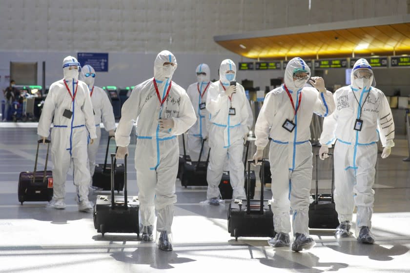 LOS ANGELES, CA - MAY 22: Hainan Airlines flight crew in full biohazard suit at Tom Bradley Terminal. Due to global pandemic and upcoming Memorial Day Weekend travelers are strongly advised to follow mask and social distancing recommendations at Los Angeles International Airport. Los Angeles Airport LAX on Friday, May 22, 2020 in Los Angeles, CA. (Irfan Khan / Los Angeles Times)