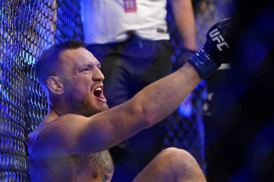 Conor McGregor yells as he sits on the mat after an injury during his lightweight mixed martial arts bout with Dustin Poirier at UFC 264 on Saturday, July 10, 2021, in Las Vegas. (AP Photo/John Locher)