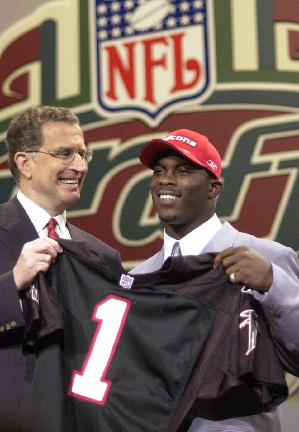 Quarterback Michael Vick, right, of Virginia Tech, is presented with a jersey by NFL Commissioner Paul Tagliabue after he was chosen by the Atlanta Falcons as the No. 1 pick of the NFL draft April 21, 2001, in New York.