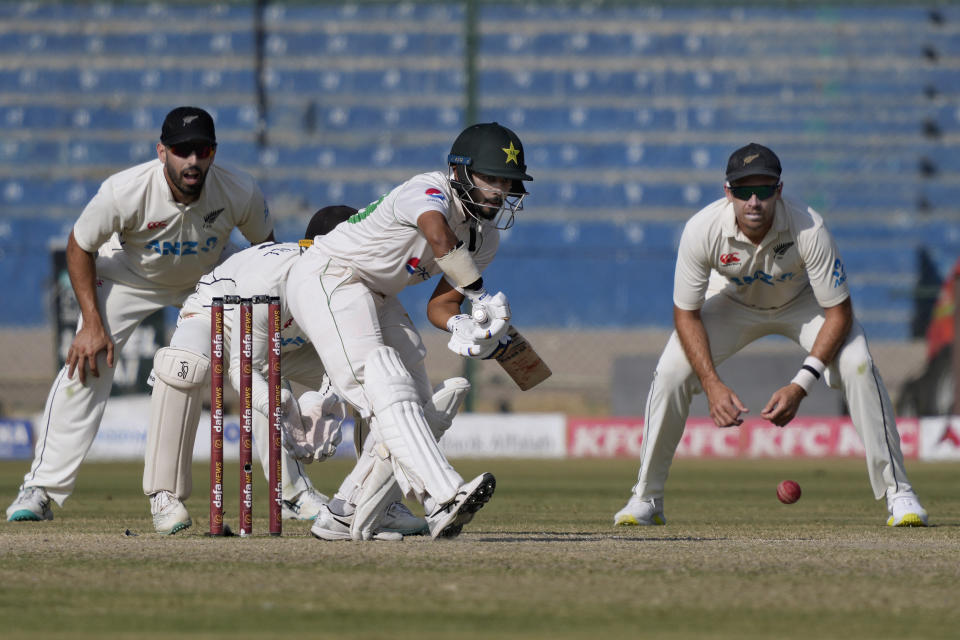 Pakistan's Saud Shakeel, center, plays a shot as New Zealand's Tim Southee, right, and Daryl Mitchell, left, watch during the fifth day of first test cricket match between Pakistan and New Zealand, in Karachi, Pakistan, Friday, Dec. 30, 2022. (AP Photo/Fareed Khan)