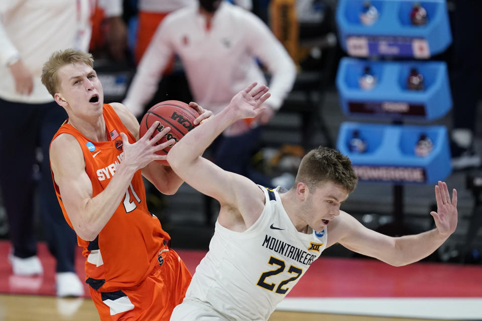 Syracuse's Marek Dolezaj (21) is fouled by West Virginia's Sean McNeil (22) as he goes to the basket during the second half of a second-round game in the NCAA men's college basketball tournament at Bankers Life Fieldhouse, Sunday, March 21, 2021, in Indianapolis. (AP Photo/Darron Cummings)