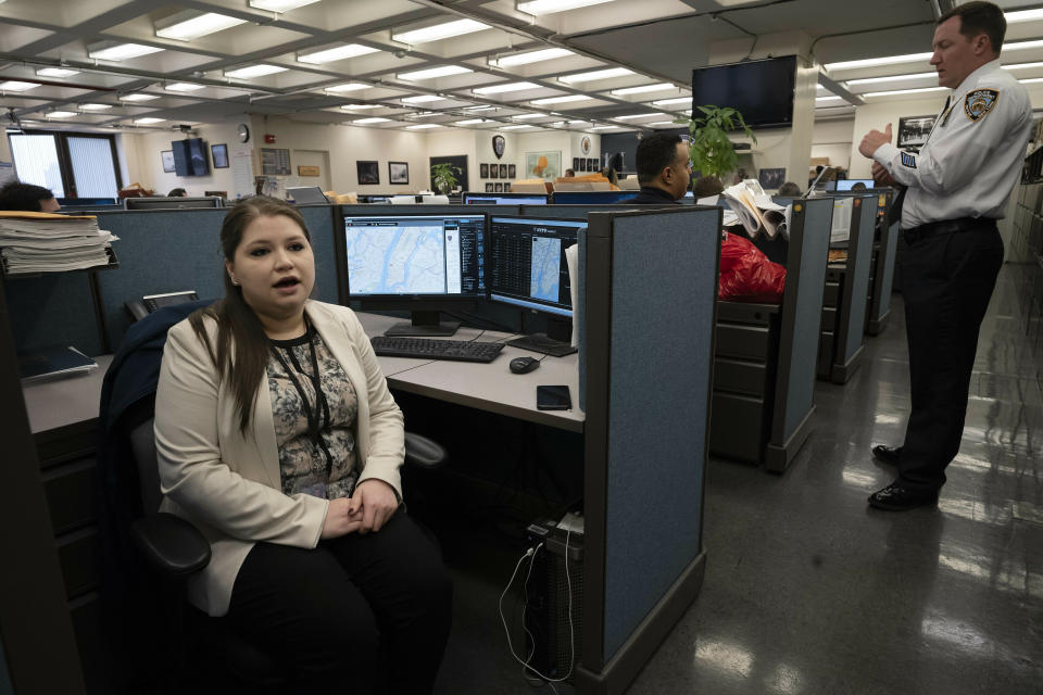 In this Feb. 11, 2019 photo, Rebecca Shutt, left, who works in the New York Police Department's Office of Crime Control Strategies, speaks in New York. Shutt utilizes a software called Patternizr, which allows crime analysts to compare robbery, larceny and theft incidents to the millions of crimes logged in the NYPD's database, aiding their hunt for crime patterns. It's much faster than the old method, which involved analysts sifting through reports and racking their brains for similar incidents. (AP Photo/Mark Lennihan)