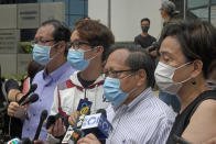 Various defendants including pro-democracy activists, from left, Richard Tsoi, Figo Chan and Albert Ho speak to media outside a court in Hong Kong, Monday, May 17, 2021. Trial starts for Jimmy Lai and nine others, accused of "incitement to knowingly take part in an unauthorized assembly" for a protest march on Oct. 1, 2019. The court has estimated 10 days for this trial. (AP Photo/Kin Cheung)