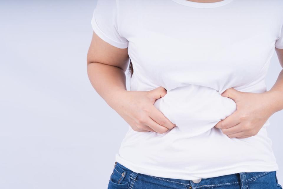 Close up woman holding excessive belly fat.