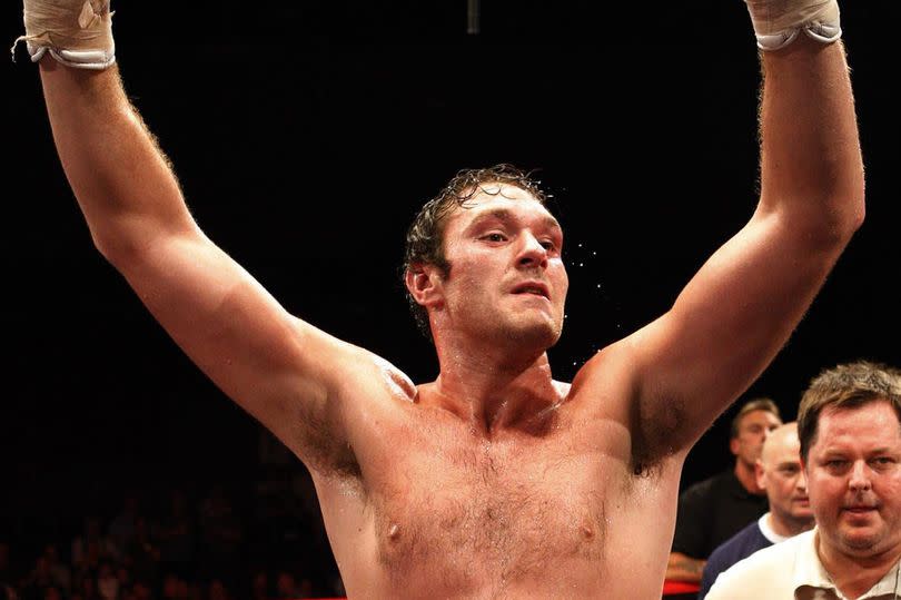 Tyson Fury poses with the belt as he celebrates his victory on the referees decision over John McDermott during the English Heavyweight Title bout at the Brentwood Centre, Essex.