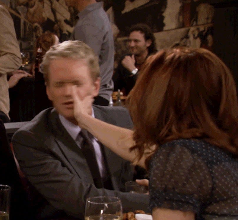 a woman leans over the table to smack her date