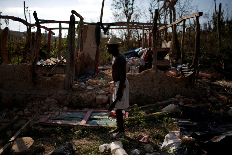 A man stands in front of his destroyed house on Oct. 15, 2016.