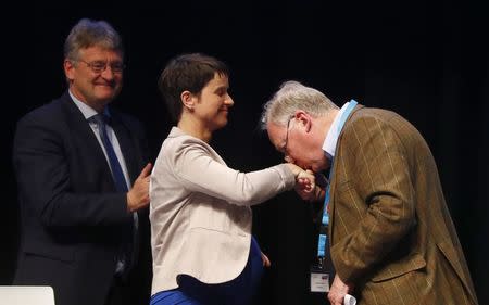 Alexander Gauland of Germany's anti-immigration party Alternative for Germany (AFD) kisses the hand of party chairwoman Frauke Petry as Joerg Meuthen looks on during an AFD party congress in Cologne Germany, April 23, 2017. REUTERS/Wolfgang Rattay