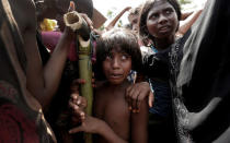 A Rohingya refugee girl reacts as people scuffle while waiting to receive aid in Cox's Bazar, Bangladesh, September 25, 2017. REUTERS/Cathal McNaughton