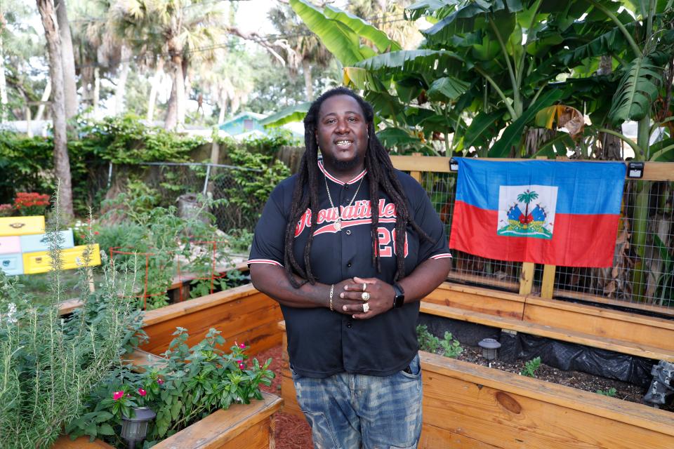 Corey "Goo" Paul wears a jersey and smiles while standing in his garden.