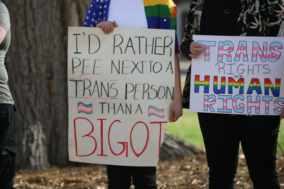 Protesters hold signs at the Statehouse on Friday to urge the Kansas Legislature against passing anti-transgender legislation.