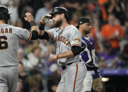 San Francisco Giants' Steven Duggar, left, congratulates Brandon Belt as he crosses home plate after hitting a three-run home run off Colorado Rockies starting pitcher Jon Gray in the fifth inning of a baseball game Saturday, Sept. 25, 2021, in Denver. (AP Photo/David Zalubowski)