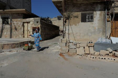 A woman drags a cart loaded with water containers in Aleppo's Sheikh Maqsoud neighbourhood, Syria July 15, 2017. REUTERS/Omar Sanadiki