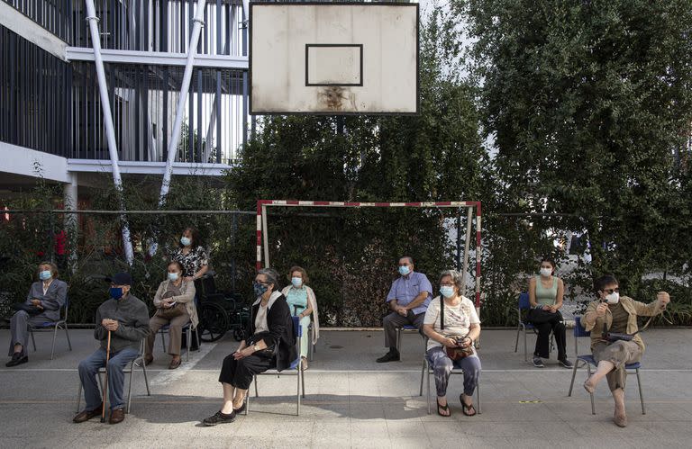 Con distanciamiento social y barbijos, la gente espera recibir su segunda dosis de la vacuna Sinovac en Santiago, Chile