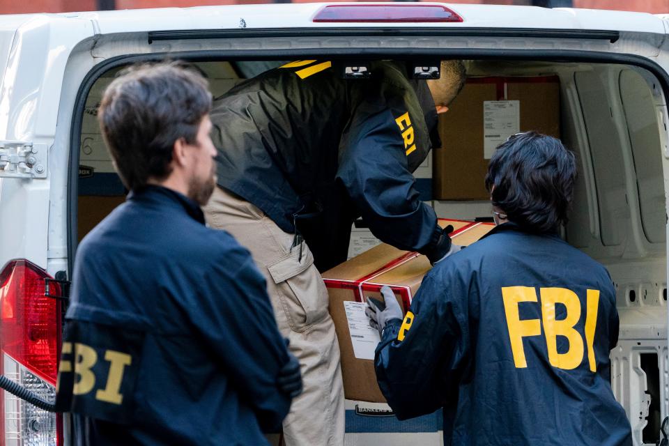 Federal agents load a vehicle with evidence boxes in October 2021. 