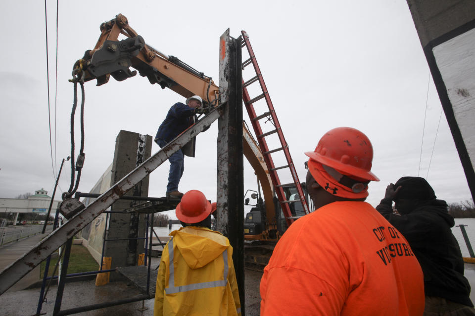 Workers with the City of Vicksburg start construction on one of the three flood wall gates on Levee Street in Vicksburg Miss., on Thursday Feb. 21, 2019. According to the National Weather Service the Mississippi River is currently at 44.69 feet and is expected to reach 48.9 feet. (Courtland Wells/The Vicksburg Post, via AP)