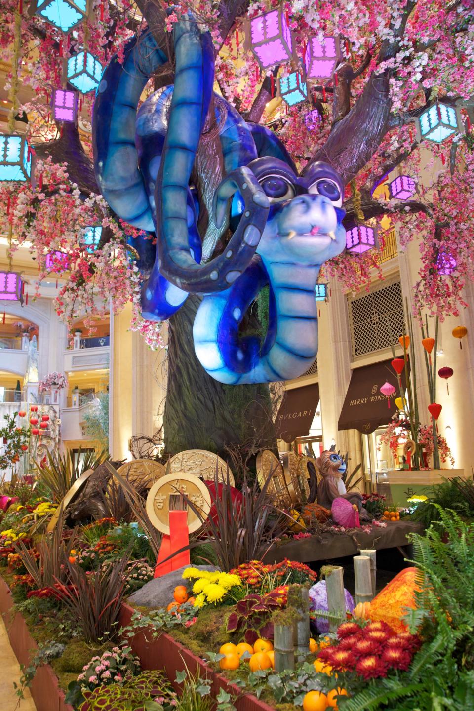 This January 2013 photo provided by The Venetian in Las Vegas shows a Chinese New Year art installation welcoming the year of the snake in the waterfall atrium connecting The Venetian and The Palazzo resorts. The display features an animatronic snake coiled in a tree decorated with flowers, lanterns and coins. Las Vegas celebrates Chinese New Year in a big way with feasts, exhibits, performances and other events around the city. The year of the snake begins Feb. 10. (AP Photo/The Venetian, Audrey Dempsey)