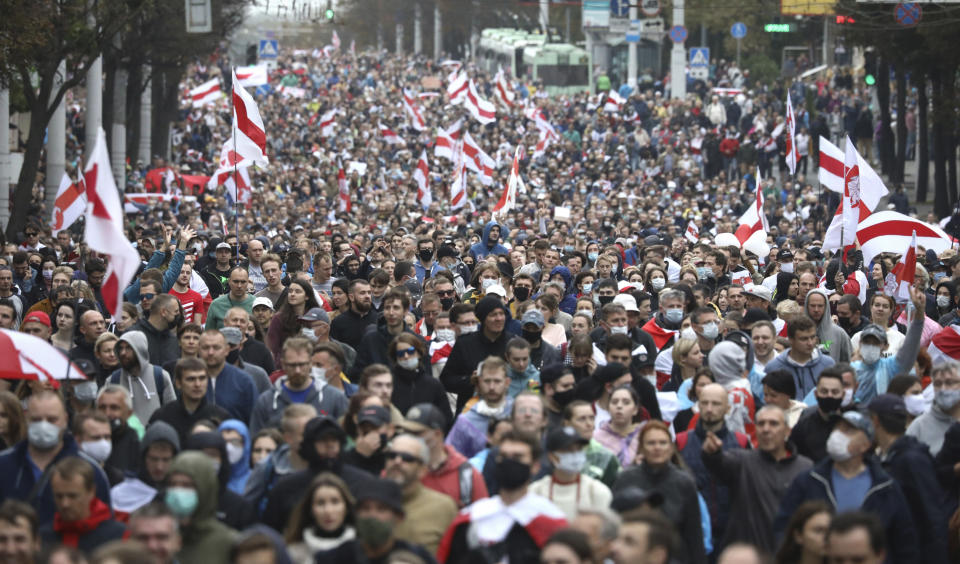 People with old Belarusian national flags march during an opposition rally to protest the official presidential election results in Minsk, Belarus, Sunday, Sept. 27, 2020.Hundreds of thousands of Belarusians have been protesting daily since the Aug. 9 presidential election. (AP Photo/TUT.by)