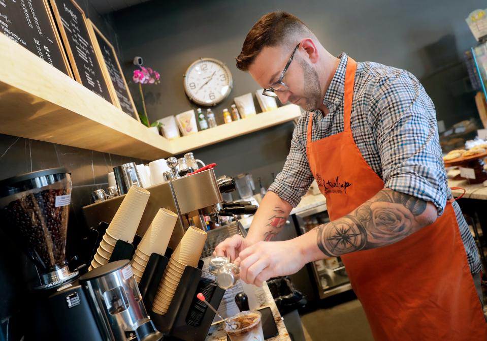 Owner Aaron Phillipson makes an iced beverage at the All Tied Up Floral Café in Appleton.