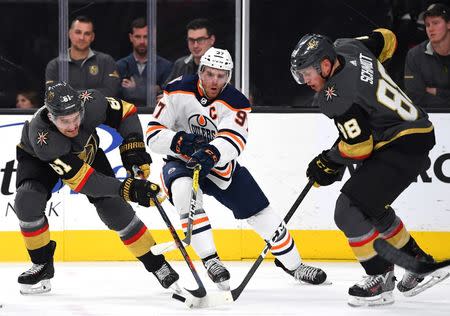 Apr 1, 2019; Las Vegas, NV, USA; Vegas Golden Knights right wing Mark Stone (61) and Vegas Golden Knights defenseman Nate Schmidt (88) take the puck away from Edmonton Oilers center Connor McDavid (97) during the third period at T-Mobile Arena. Mandatory Credit: Stephen R. Sylvanie-USA TODAY Sports