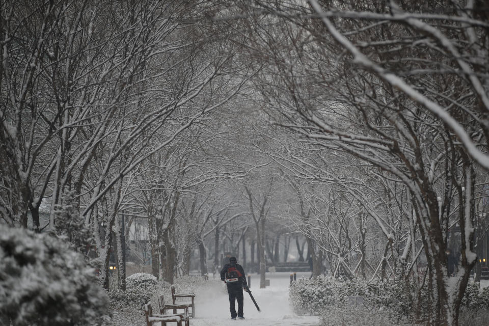 A man clears the snow at a park in Goyang, South Korea, Tuesday, Jan. 12, 2021. (AP Photo/Lee Jin-man)