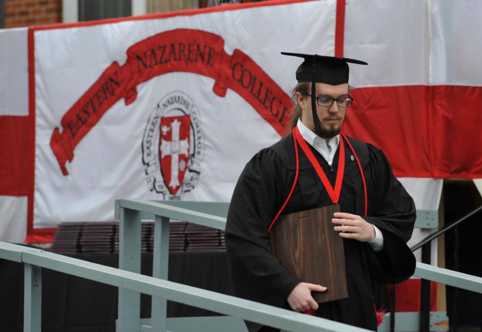 Jaben Beiler proudly holds his Outstanding Senior Award during the Eastern Nazarene College 100th commencement in Quincy, Saturday, May 7, 2022.