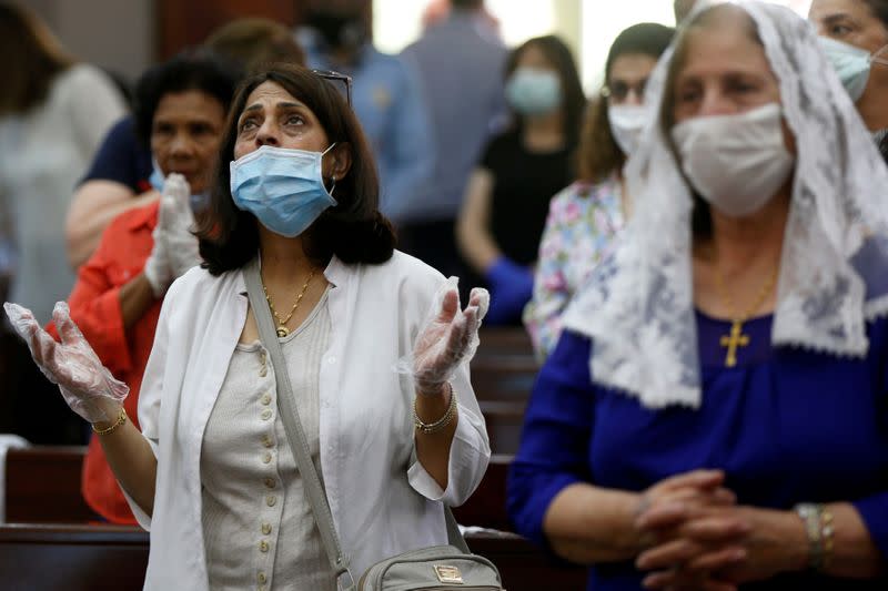 People wearing face masks attend a mass at the Church of Mary of Nazareth, in downtown Amman