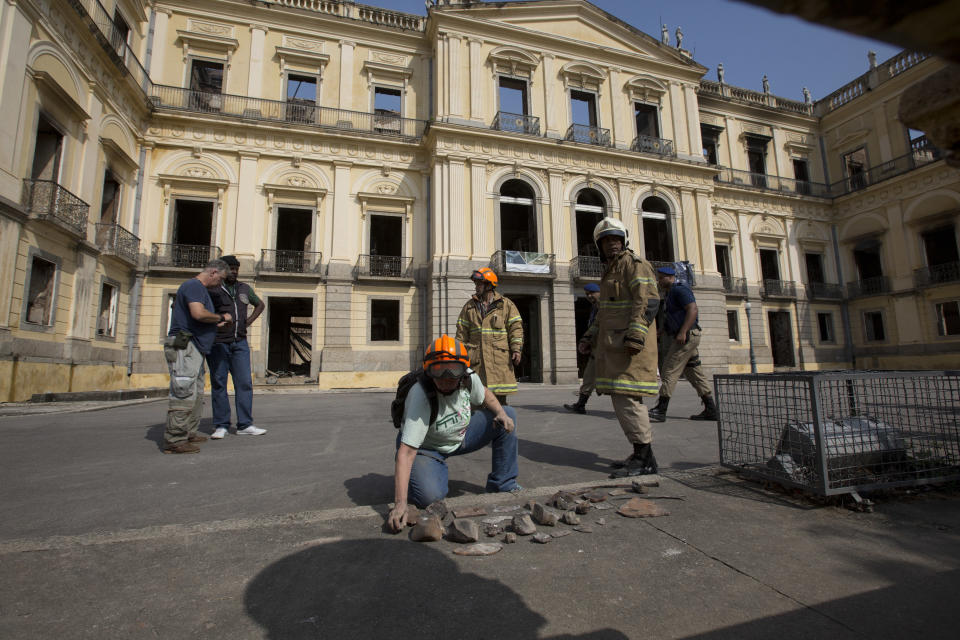 A National Museum worker organizes pieces rescued from the museum after an overnight fire in Rio de Janeiro, Brazil, Monday, Sept. 3, 2018. A huge fire engulfed Brazil's 200-year-old National Museum in Rio de Janeiro, lighting up the night sky with towering flames as firefighters and museum workers raced to save historical relics from the blaze. (AP Photo/Silvia Izquierdo)