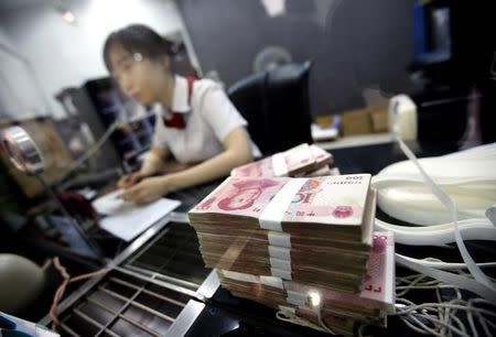 An employee of the Industrial and Commercial Bank of China Ltd (ICBC) talks to a customer at one of the bank's branch at the Shanghai Free Trade Zone in Pudong district, in Shanghai September 24, 2014. REUTERS/Carlos Barria