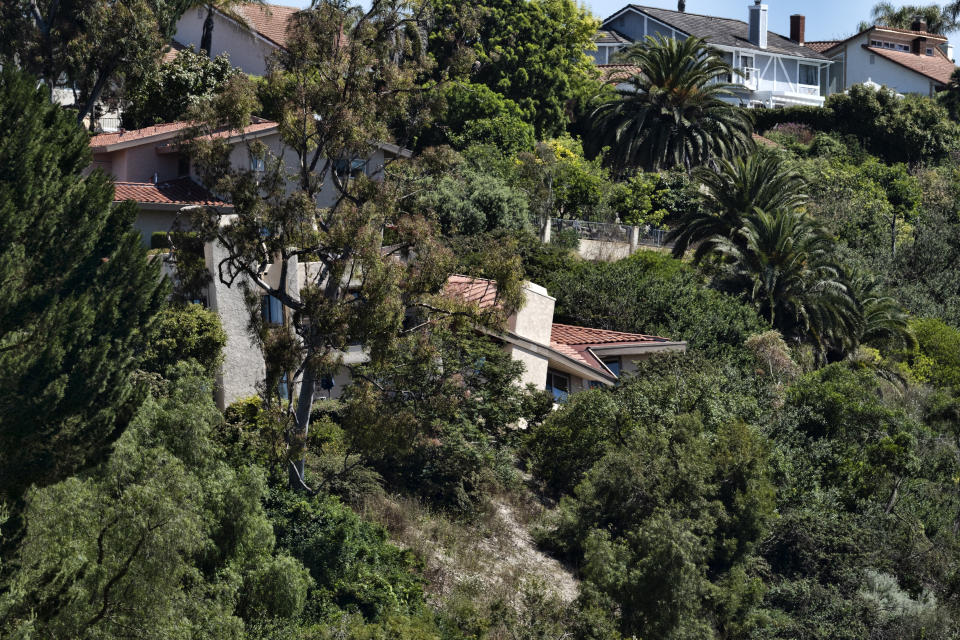 A house in Rolling Hills Estates severely damaged from a landslide teeters over a densely wooded ravine on the Palos Verdes Peninsula in Los Angeles County, on Monday, July 10, 2023. The Los Angeles County city of Rolling Hills Estates were hastily evacuated by firefighters Saturday when cracks began appearing in structures and the ground. (AP Photo/Richard Vogel)