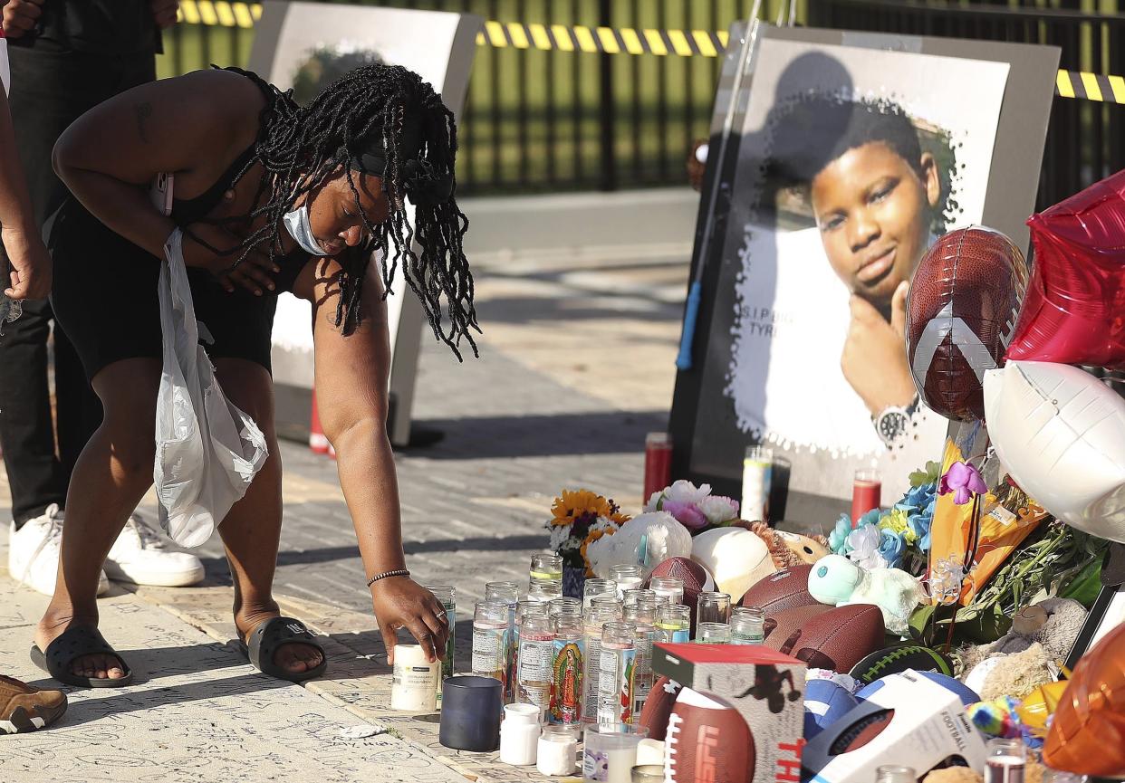 Family members and friends of Tyre Sampson leave items during a vigil in front of the Orlando Free Fall drop tower in ICON Park in Orlando on Monday, March 28, 2022.