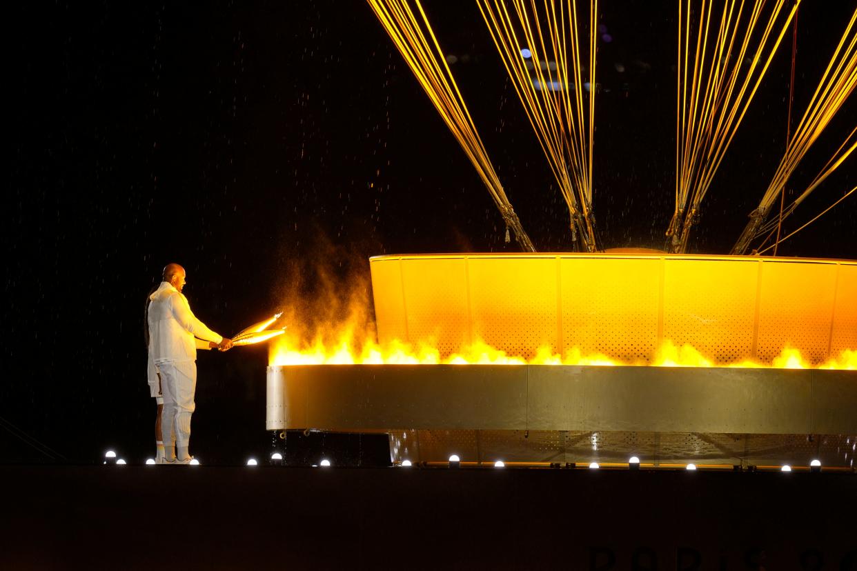 Teddy Riner and Marie-Jose Perec light the cauldron during the Opening Ceremony for the Paris 2024 Olympic Summer Games.