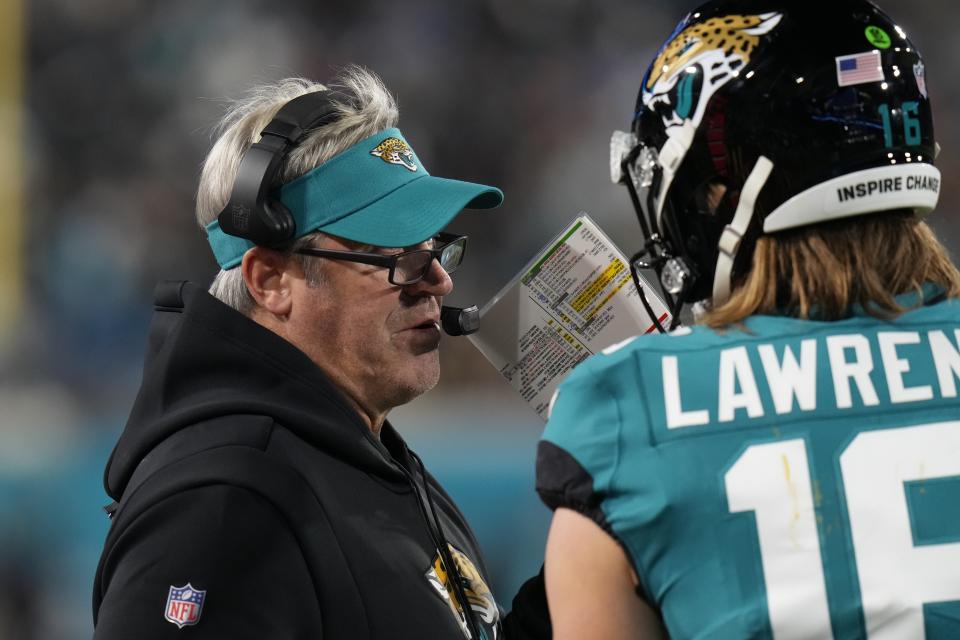 Jacksonville Jaguars head coach Doug Pederson, left, speaks to Jacksonville Jaguars quarterback Trevor Lawrence (16) on the sidelines during the first half of an NFL wild-card football game against the Los Angeles Chargers, Saturday, Jan. 14, 2023, in Jacksonville, Fla. (AP Photo/Chris O'Meara)