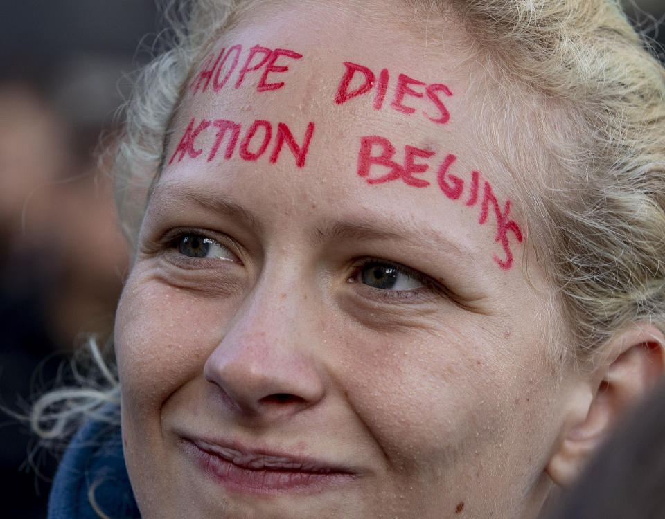 An activists blocks the main entrance of the fairground in Frankfurt, Germany, Sunday, Sept. 15, 2019. They protest against the government's transport policy on occasion of the IIA Auto Show taking place. (AP Photo/Michael Probst)