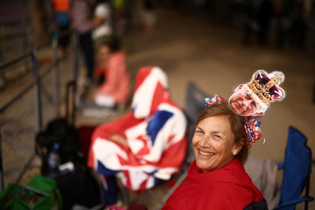 A royal fan sits along The Mall prior to the King's Birthday Parade (AFP via Getty Images)
