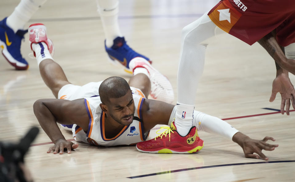 Phoenix Suns guard Chris Paul falls on the floor while pursuing a loose ball in the first half of Game 4 of an NBA second-round playoff series agtainst the Denver Nuggets Sunday, June 13, 2021, in Denver. (AP Photo/David Zalubowski)
