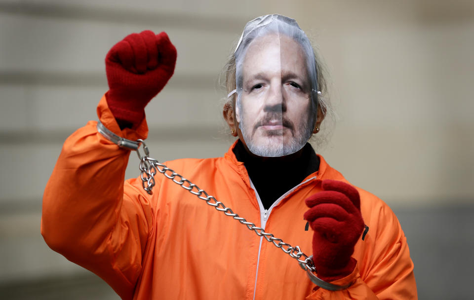 A demonstrator supporting Julian Assange wears a mask and chains outside Westminster Magistrates Court in London, Thursday, Jan. 23, 2020. Assange is scheduled to be presented before the court by videolink, for a case management hearing ahead of his full extradition trial which begins on Feb. 24. (AP Photo/Kirsty Wigglesworth)
