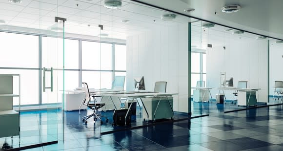 Modern office interior showing glassed-in conference rooms and contemporary furniture.