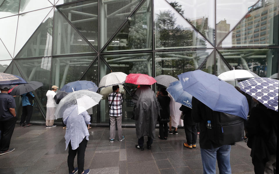 People stand outside of Seoul City Hall where official funeral of late Seoul Mayor Park Won-soon is held in Seoul, South Korea, Monday, July 13, 2020. Masked mourners gave speeches and laid flowers before the coffin of Seoul's mayor during his funeral Monday, while a live broadcast online drew a mixture of condolence messages and insults. (AP Photo/Lee Jin-man)