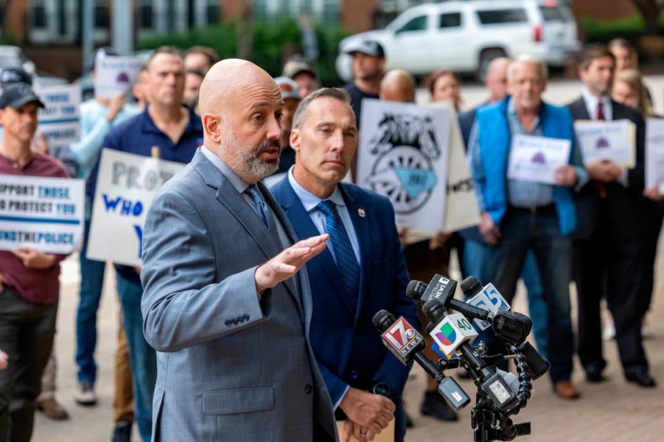 Matthew Cooper, president, left, and Rick Armstrong, spokesperson, for the of the Raleigh Police Protective Association along with dozens of police  officers, demand higher pay from the city of Raleigh during a rally outside city hall on Tuesday, April 9, 2024.