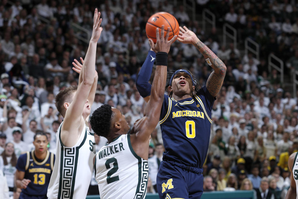 Michigan's Dug McDaniel, right, shoots against Michigan State's Tyson Walker (2) and Jaxon Kohler, left, during the first half of an NCAA college basketball game, Saturday, Jan. 7, 2023, in East Lansing, Mich. (AP Photo/Al Goldis)