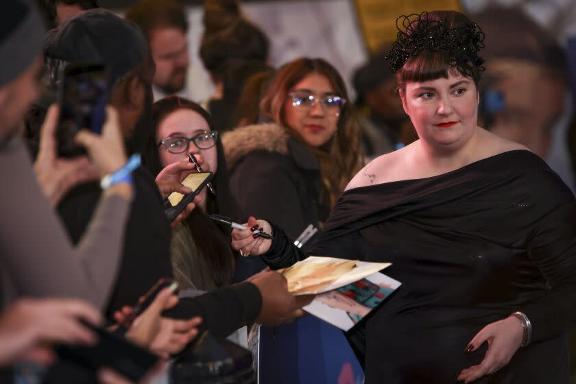 Director Lena Dunham, right, signs autographs upon arrival for the UK premiere of the film 'Catherine Called Birdy'