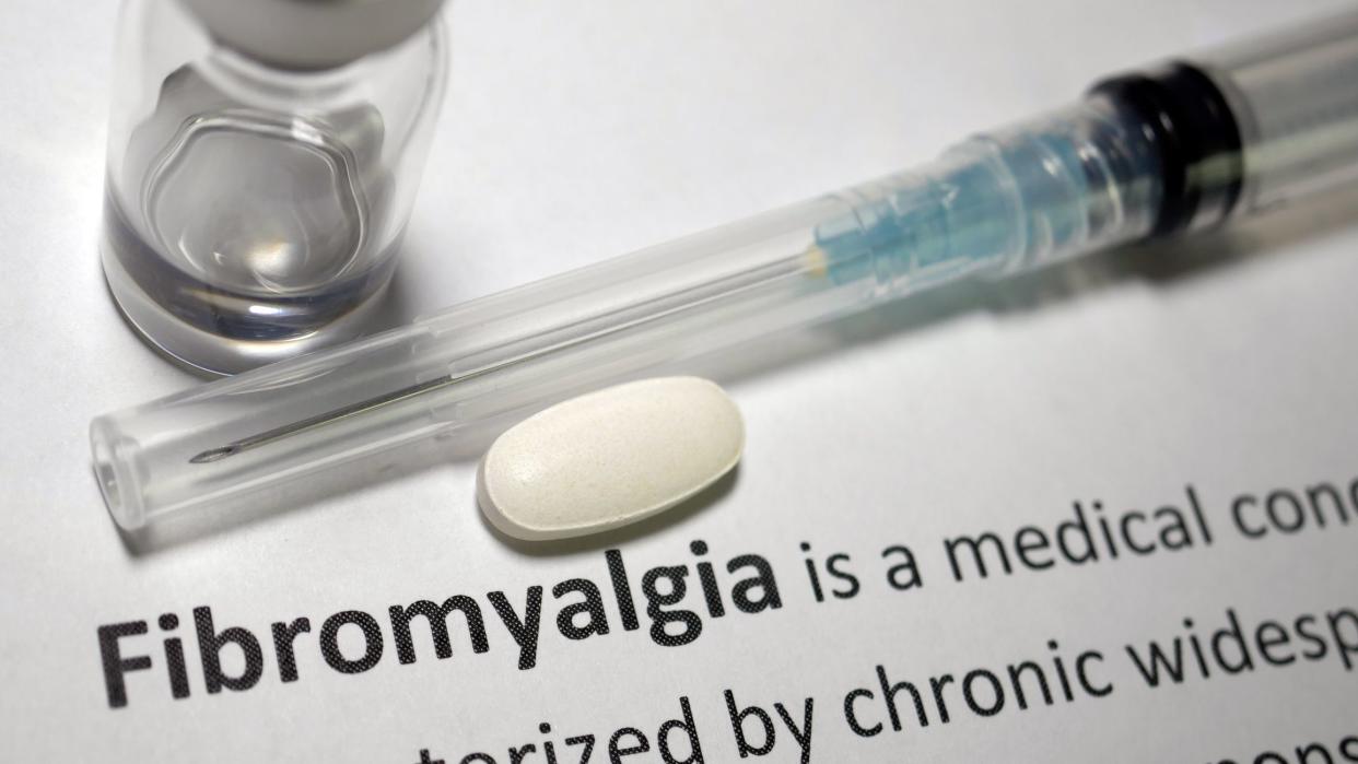 Fibromyalgia text with needle and pill