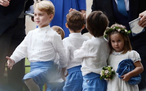 Princess Charlotte appeared unimpressed with her brother's marching game as she clutched a bag and posy of flowers after the wedding - Credit: Mark Stewart Photography