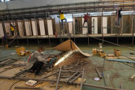 Workers prepare a field hospital set up inside a cargo building in Don Mueang International Airport in Bangkok, Thailand, Thursday, July 29, 2021. Health authorities raced on Thursday to set up yet another large field hospital in Thailand's capital as the country recorded a new high in COVID-19 cases and deaths. The hospital, one of many already in use, was being set up at one of Bangkok's two international airports after the capital ran out of hospital beds for thousands of infected residents. (AP Photo/Sakchai Lalit)