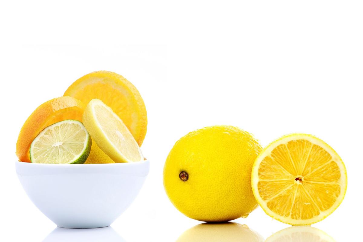 fresh ripe whole lemons in eco string bag on yellow background