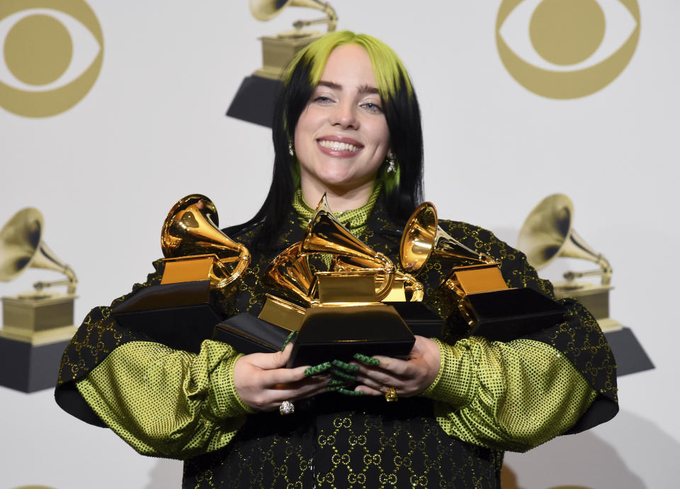 Billie Eilish poses in the press room with the awards for best album and best pop vocal album for "We All Fall Asleep, Where Do We Go?", best song and record for "Bad Guy" and best new artist at the 62nd annual Grammy Awards at the Staples Center on Sunday, Jan. 26, 2020, in Los Angeles. (AP Photo/Chris Pizzello)