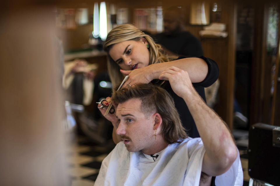 Country singer Morgan Wallen receives a mullet at Paul Mole Barber Shop on Tuesday, Aug. 27, 2019, in New York. Wallen, who has turned heads with his likable hit song “Whiskey Glasses," said he decided to try a mullet after seeing old photos of his dad proudly rocking the hairstyle. (Photo by Charles Sykes/Invision/AP)
