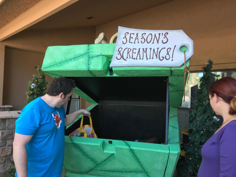 Francis (left) and Jessica Brown put out a a monster-sized gift box to collect donated items for Sojourner Center, which aids victims of domestic violence. The Tempe couple asks visitors to donate toys and goods for children and adults.